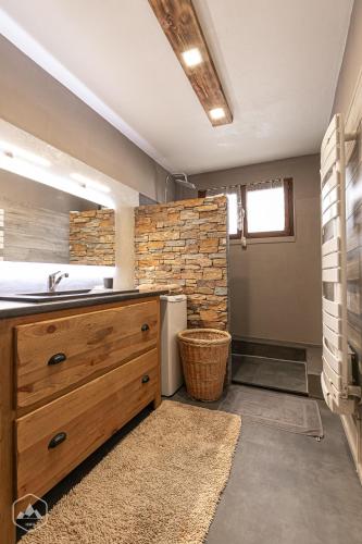 a bathroom with a sink and a stone wall at Gîte Le Cembro 6 personnes in Termignon