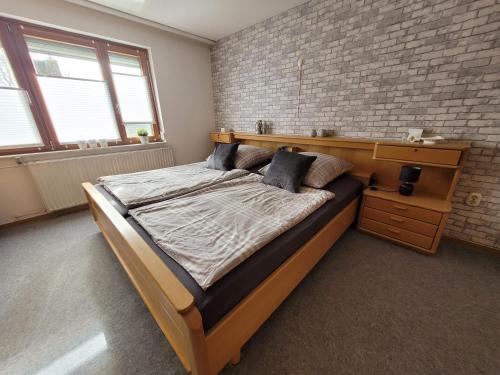 ein großes Bett in einem Zimmer mit einer Backsteinwand in der Unterkunft Am Strohberg in Petersburg