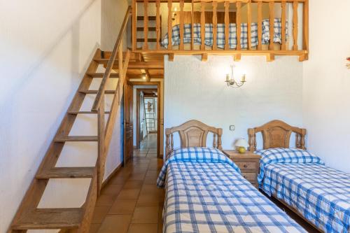 two beds in a room with a bunk bed at La Cárcava in La Serna del Monte