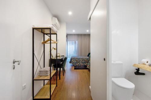 a room with a toilet and a table with a desk at Jm Stay in Aveiro
