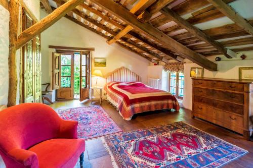 a bedroom with a bed and a chair in a room at Maison De Charme Avec Jacuzzi in Arcangues