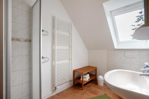a bathroom with a white tub and a window at Ferienwohnung Coni in Langballig
