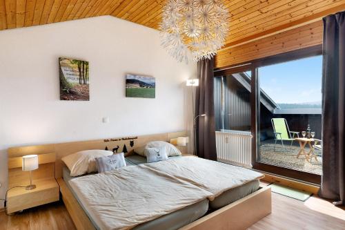 una camera da letto con un grande letto e una grande finestra di Klug a Schonach