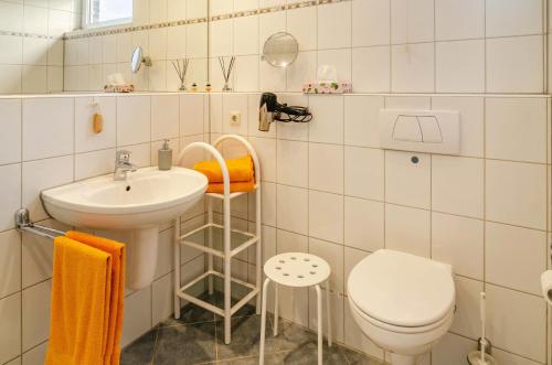 a white bathroom with a sink and a toilet at Ferienhaus 'am Gänsepfad' in Hage