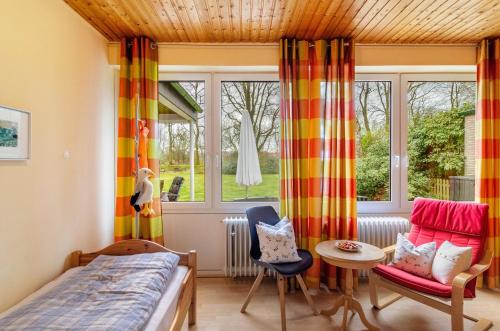 a bedroom with a bed and a table and a window at Ferienhaus 'am Gänsepfad' in Hage