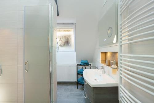 a white bathroom with a sink and a shower at Ferienwohnung Sophie in Lauchhammer