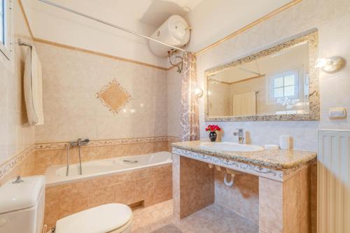 a bathroom with a toilet and a tub and a sink at Even Ezer with private pool in Pouládes