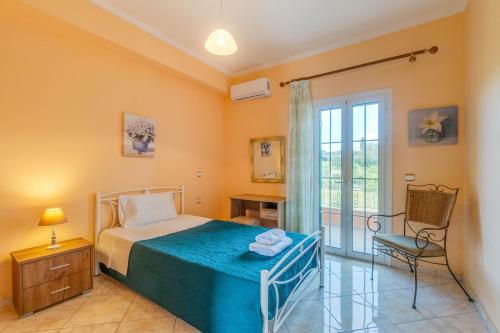a bedroom with a bed and a chair and a window at Even Ezer with private pool in Pouládes