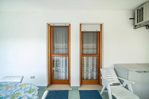 a room with three windows and a bed and a desk at Appartamento Passeggiata al Mare in Bibione
