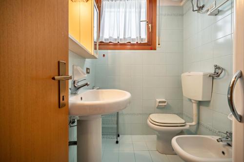 a bathroom with a toilet and a sink at Appartamento Passeggiata al Mare in Bibione