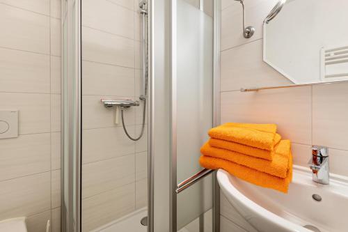 a bathroom with a shower and yellow towels at Ferienwohnung Gruber in Bodenwöhr