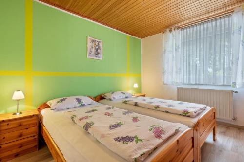 two beds in a room with green walls at Ferienwohnung Gruber in Bodenwöhr