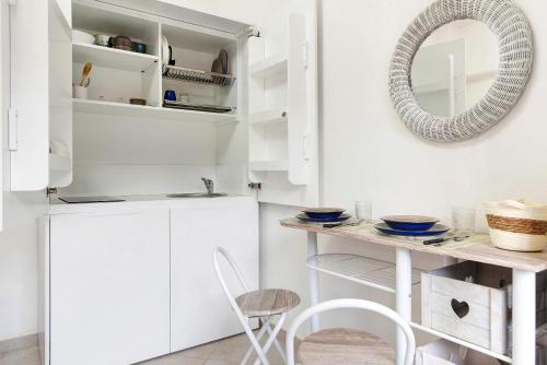 a kitchen with white cabinets and a table and chairs at Margherita - Fronte Mare in Rapallo