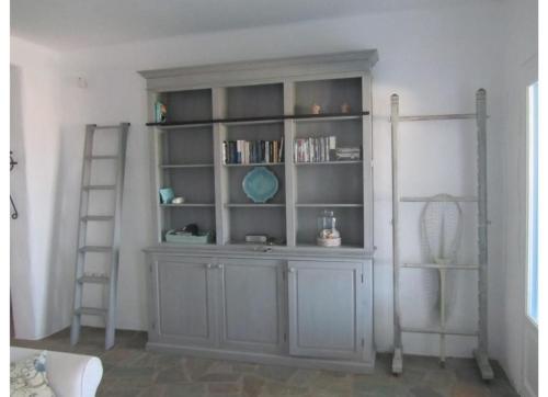 a room with a gray book shelf with books at Villa Galazio in Kampos Paros