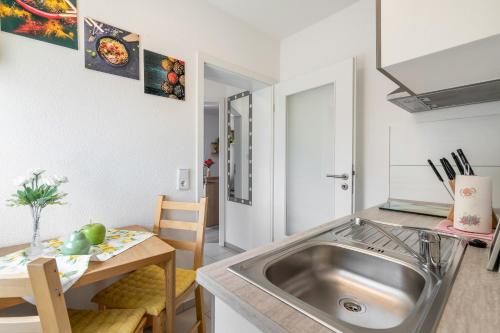 a kitchen with a stainless steel sink and a table at Ferienwohnung Marks - Hohnstein in Rathewalde