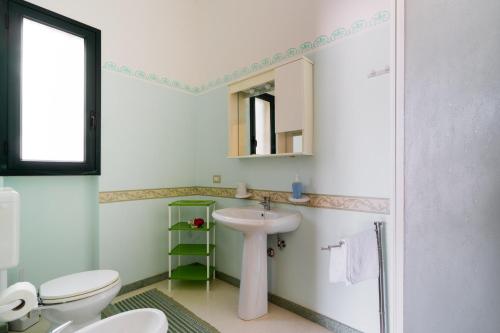 a bathroom with a sink and a toilet and a mirror at Domus mea salento Arazzo Rosso in Ugento