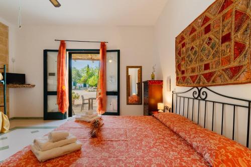 a bedroom with a bed and a large window at Domus mea salento Arazzo Rosso in Ugento