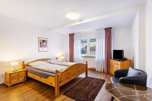 a bedroom with a bed and a living room at Ferienwohnung Kebben in Kirchhundem