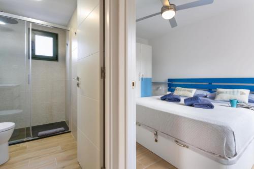 a bedroom with a bed and a shower and a toilet at Casa Del Caballero Corralejo in Corralejo