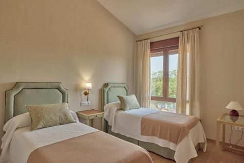a bedroom with two beds and a window at Dehesa El Alcornocal in Posadas