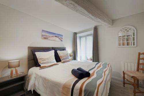 a bedroom with a large bed with a window at Le Douar Armor - cour intérieure in Dinan