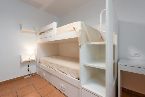 a small room with white bunk beds in it at Casa con piscina La Madriguera in Estepona