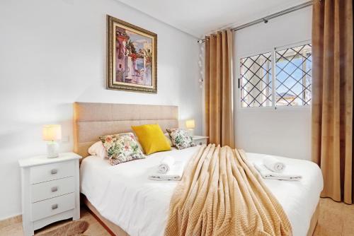 a bedroom with a white bed with a window at Parque Mar V in La Mata