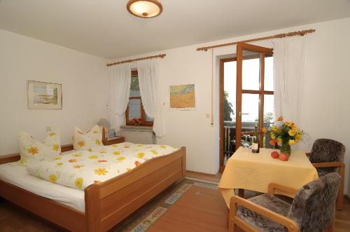a bedroom with a bed and a table and a chair at Baumanns Ferienhof Am See in Bettnau