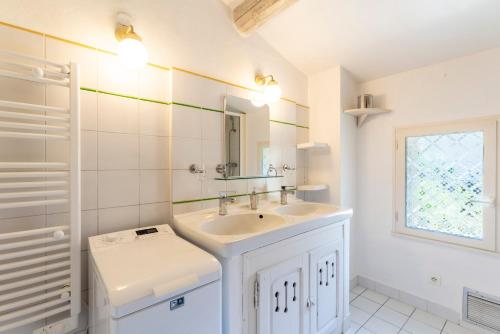 a white bathroom with a sink and a mirror at Mazet de Cabrières Gordes, Clim in Cabrières-dʼAvignon