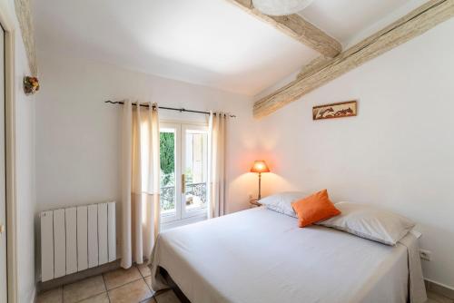 a bedroom with a white bed and a window at Mazet de Cabrières Gordes, Clim in Cabrières-dʼAvignon
