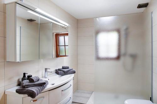 a white bathroom with a sink and a shower at Appartment Stockeben in Niederau