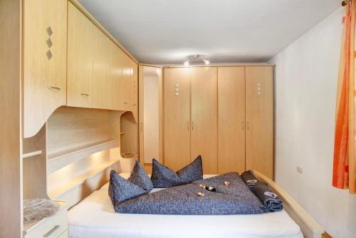 a small bedroom with a bed with blue pillows at Appartment Stockeben in Niederau