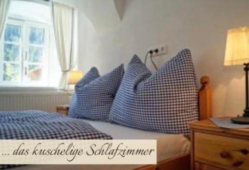 a bedroom with a bed with blue pillows at Priestereck in Obernberg am Brenner
