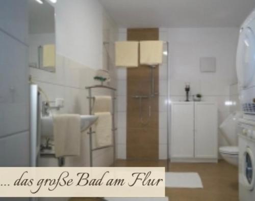 a white bathroom with a shower and a sink at Priestereck in Obernberg am Brenner