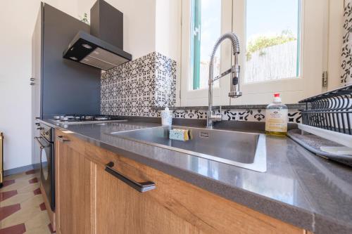 a kitchen with a stainless steel sink and a stove at La Casa Bianca in Lipari