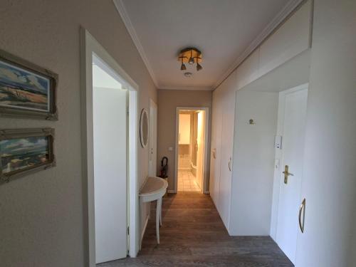 a hallway with a bathroom with a sink and a mirror at App 17 Haus Nordland in Sylt