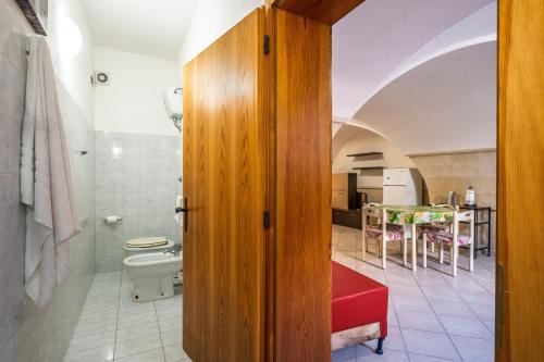 a bathroom with a toilet and a table in a room at Casa dell'Angelo in Muro Leccese
