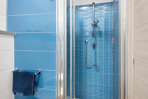 a bathroom with a shower with blue tiles at Casa mare montaretto 2 in Bonassola