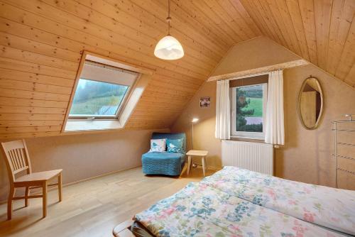 a bedroom with a bed and a chair in a room at Grundhof in Oberprechtal