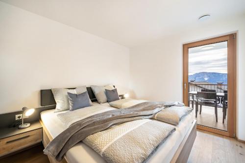a bedroom with a bed with a view of a balcony at Apartment Klara in Meltina