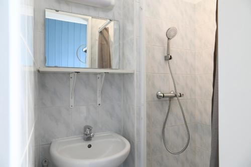 a bathroom with a sink and a shower with a mirror at Chambres d'hôtes - Chez Antho in Betton-Bettonet