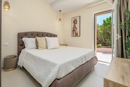 a bedroom with a bed and a sliding glass door at Villa Leone con piscina privata in Punta Molara