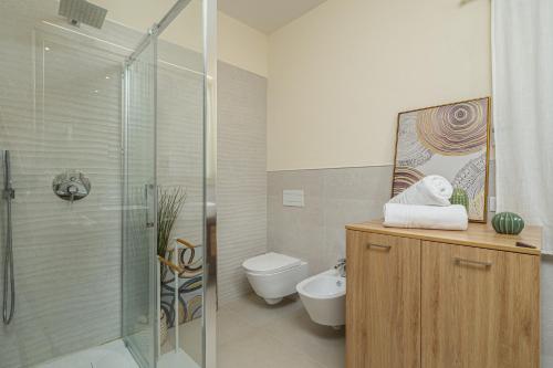 a bathroom with a shower and a toilet and a sink at Villa Leone con piscina privata in Punta Molara