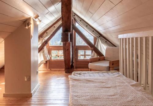 an attic bedroom with a bed and a staircase at Chalet Arclosan - Saint-Ferréol in Saint-Ferréol