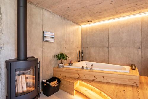 a bathroom with a fireplace and a bath tub at Chalet Bergfreund in Valdaora