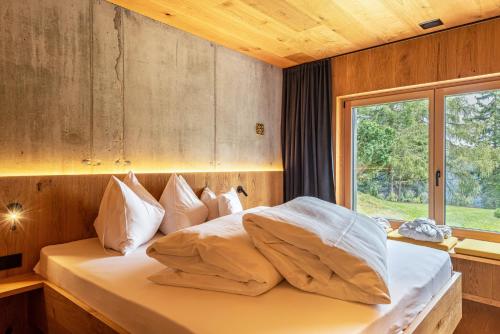 a bed in a room with a large window at Chalet Bergfreund in Valdaora