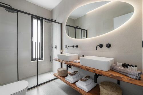 a bathroom with two sinks and a mirror at Nimbus Villas in Kalamitsi