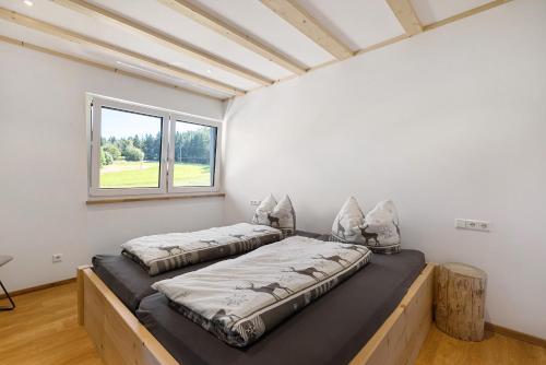 two beds in a room with a window at Kapellenhof Ferienwohnungen in Triberg