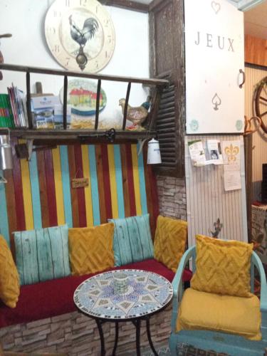 a room with a couch and a table and a clock at Room - Les loups bleus in Rossillon
