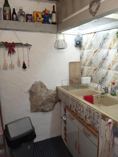 a bathroom with a sink and a rock on the wall at Room - Les loups bleus in Rossillon